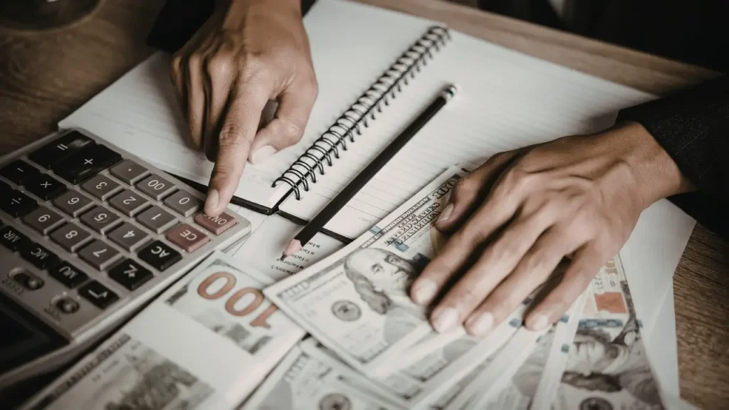 Pessoa fazendo cálculos para bem-estar financeiro 
