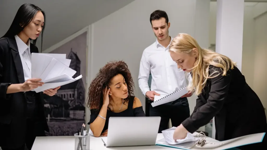 Equipe com 4 pessoas discutindo sobre psicologia organizacional

