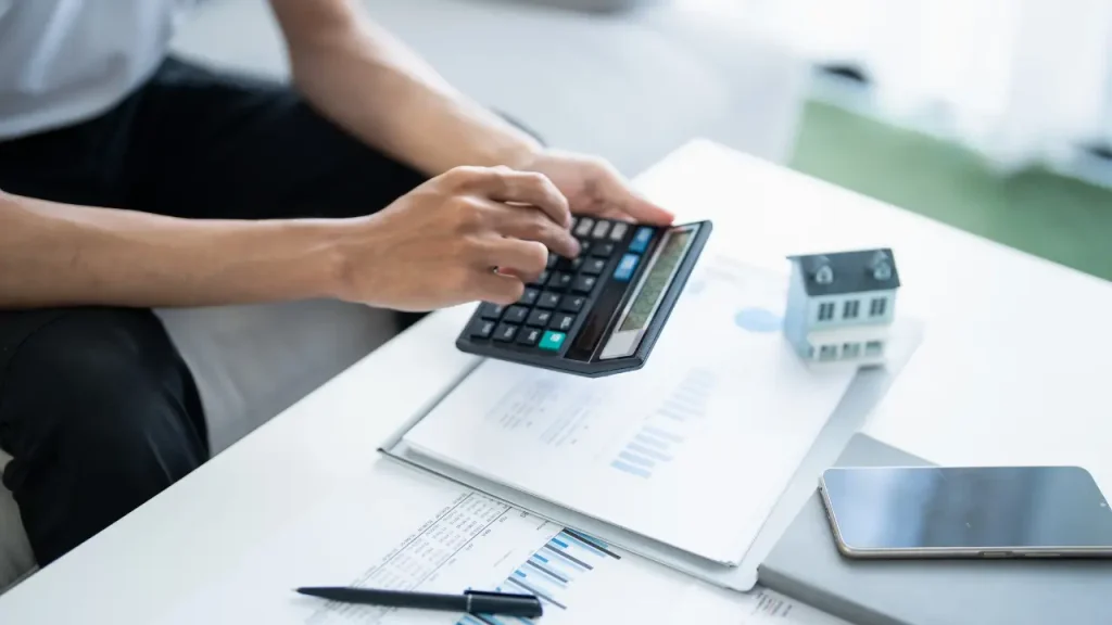 Pessoa fazendo cálculos em uma calculadora