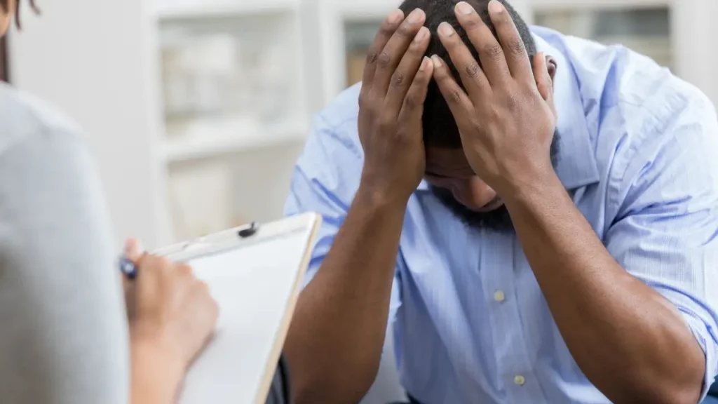 Homem com a mao na cabeça com saúde mental no ambiente de trabalho
