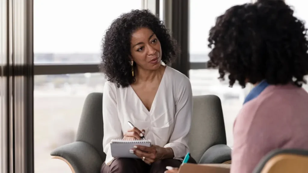 Mulher conversando com funcionária sobre saúde mental no ambiente de trabalho
