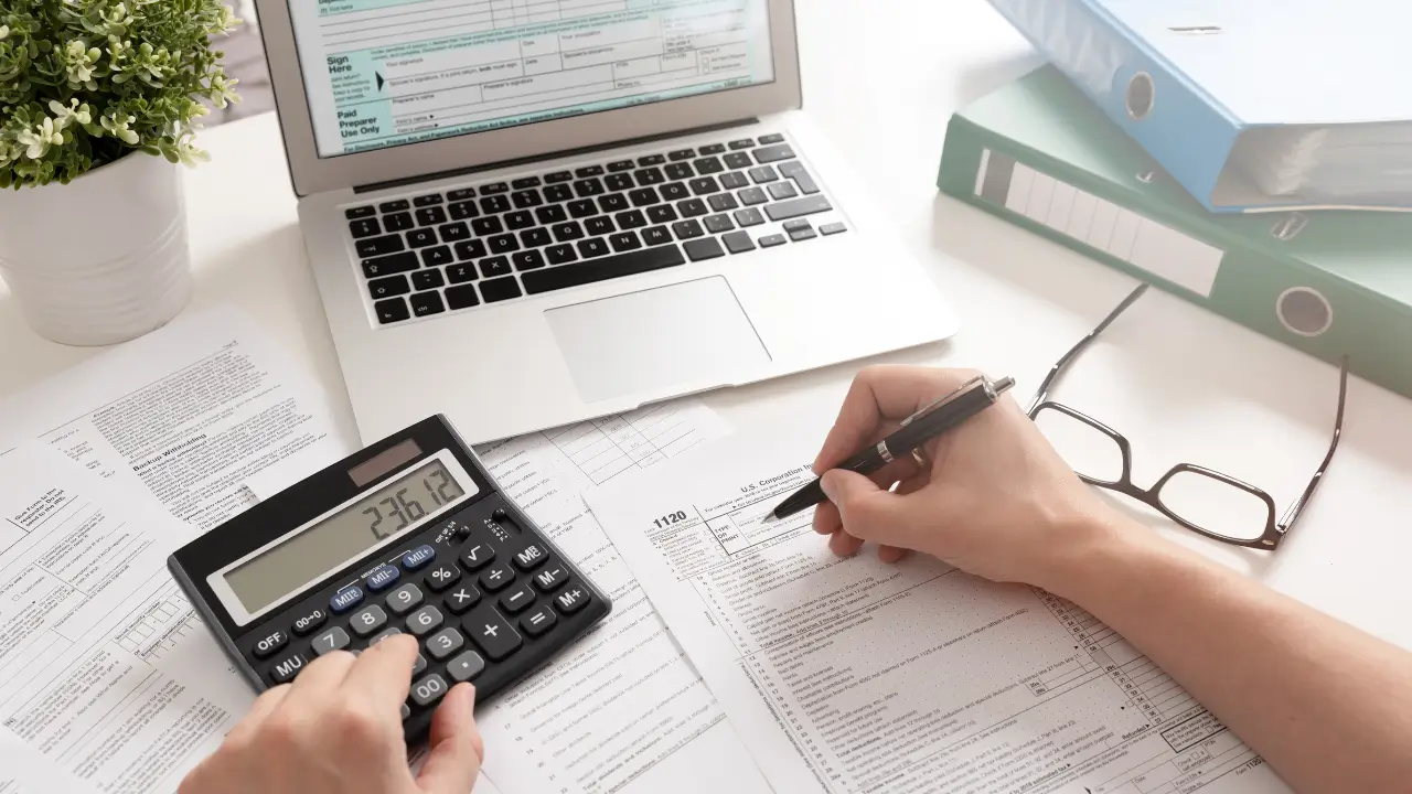 Pessoa com notebook e calculadora