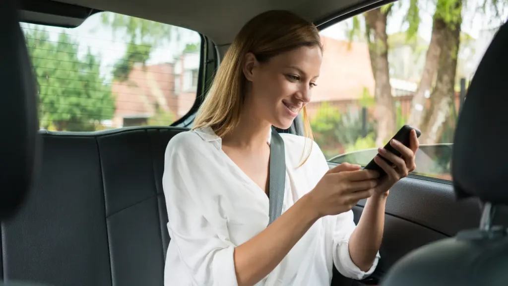 Mulher sentada no banco de tras do carro usando vale mobilidade