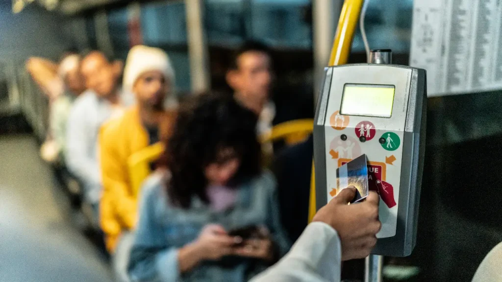 Pessoa passando cartão de vale transporte no ônibus